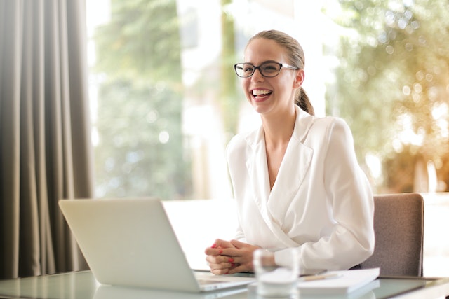 property manager sitting a their desk working on their laptop and smiling